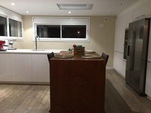 Pavimento y mueble en madera laminada par dar calidez a la cocina de esta reformade casa en Lliçà d'Amunt